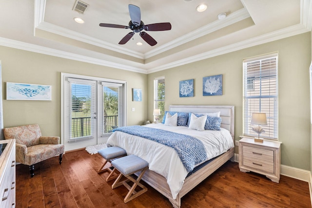 bedroom featuring ceiling fan, crown molding, a tray ceiling, and dark hardwood / wood-style floors