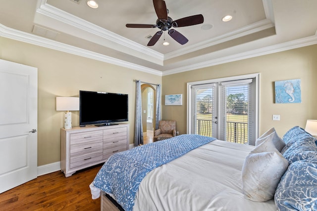 bedroom with dark hardwood / wood-style floors, a raised ceiling, ceiling fan, and crown molding