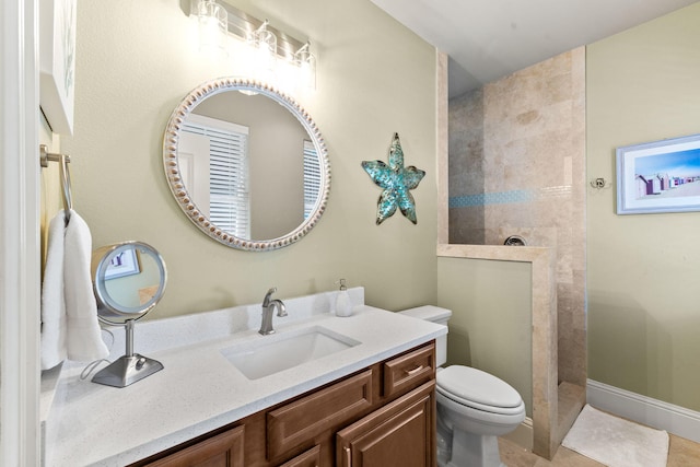 bathroom with tiled shower, vanity, toilet, and tile flooring