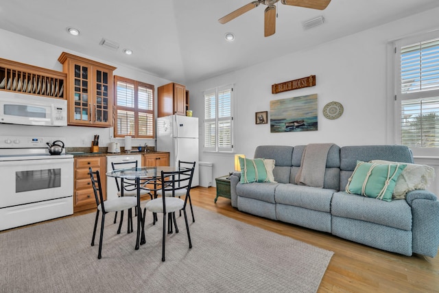 interior space featuring a healthy amount of sunlight, ceiling fan, white appliances, and light wood-type flooring