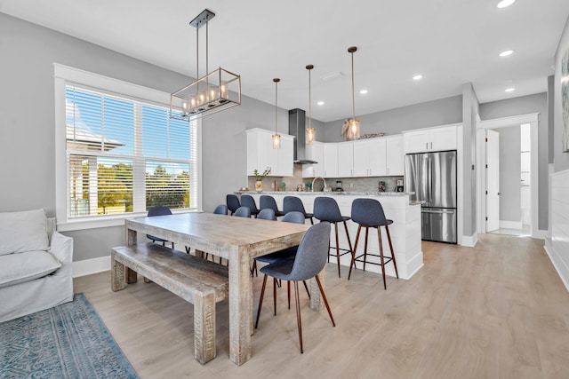 dining area with an inviting chandelier and light hardwood / wood-style floors