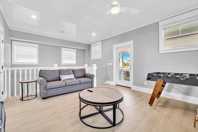 living room with light hardwood / wood-style flooring, ceiling fan, and ornamental molding