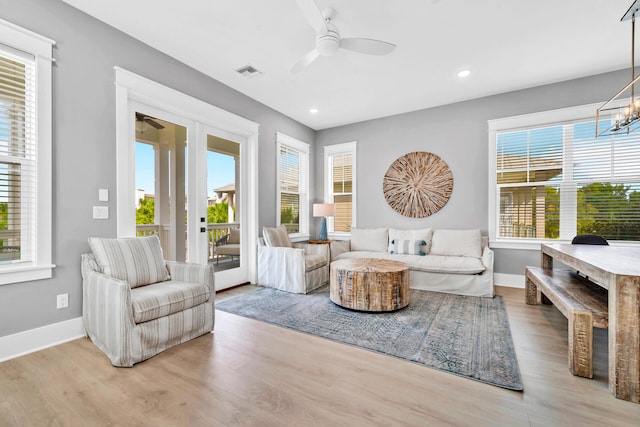 interior space with a healthy amount of sunlight, light hardwood / wood-style floors, and ceiling fan with notable chandelier