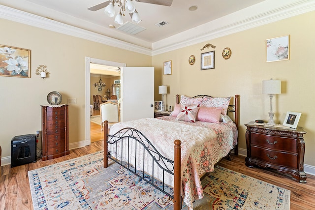 bedroom with ornamental molding, dark hardwood / wood-style flooring, and ceiling fan