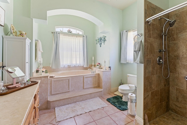 full bathroom with tile flooring, vanity, toilet, and plus walk in shower