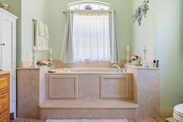 bathroom featuring toilet, a bath, and tile flooring