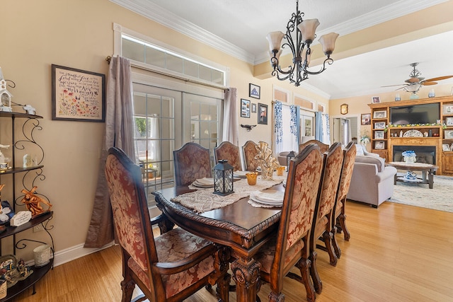 dining space featuring light hardwood / wood-style floors, ceiling fan with notable chandelier, french doors, and crown molding