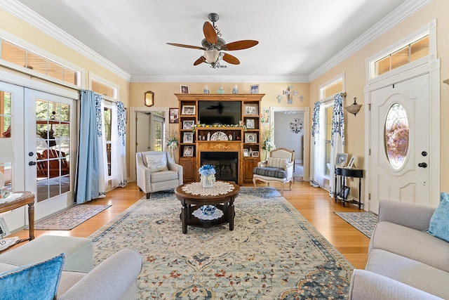 living room featuring ornamental molding, light hardwood / wood-style flooring, french doors, and ceiling fan