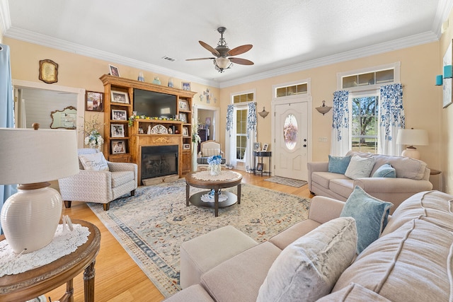 living room with ceiling fan, light hardwood / wood-style floors, and crown molding