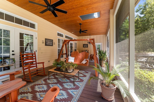 sunroom / solarium featuring wooden ceiling, a wealth of natural light, ceiling fan, and french doors