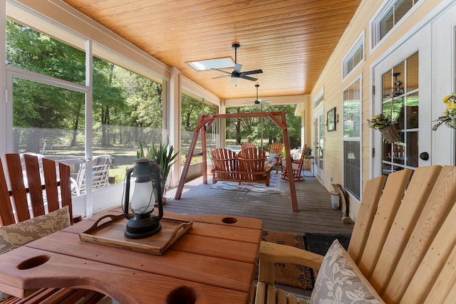 sunroom / solarium with wooden ceiling, ceiling fan, and a skylight