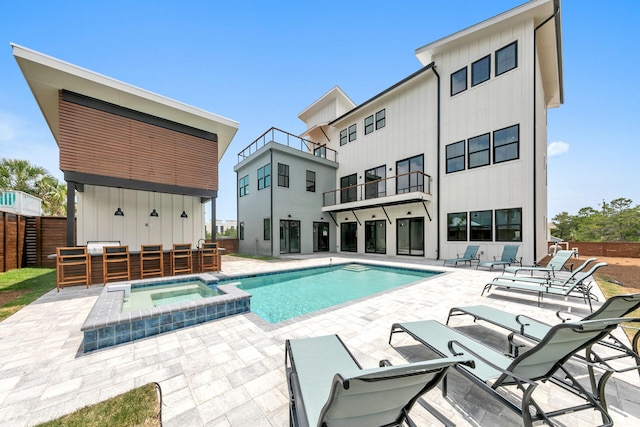 view of swimming pool featuring an in ground hot tub and a patio area