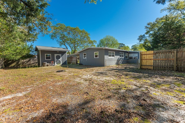 rear view of house with a storage unit