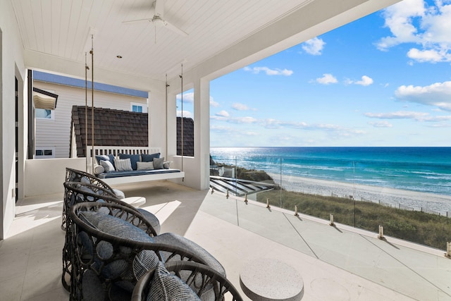 exterior space featuring a water view, a beach view, ceiling fan, and an outdoor living space