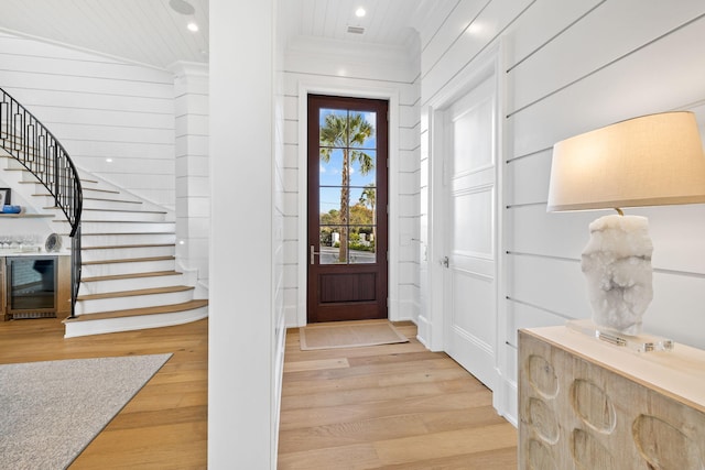 entrance foyer featuring crown molding and light hardwood / wood-style floors