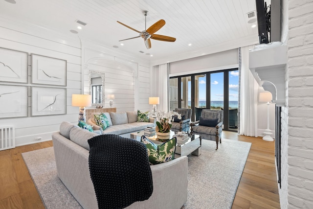 living room featuring crown molding, light hardwood / wood-style flooring, and ceiling fan