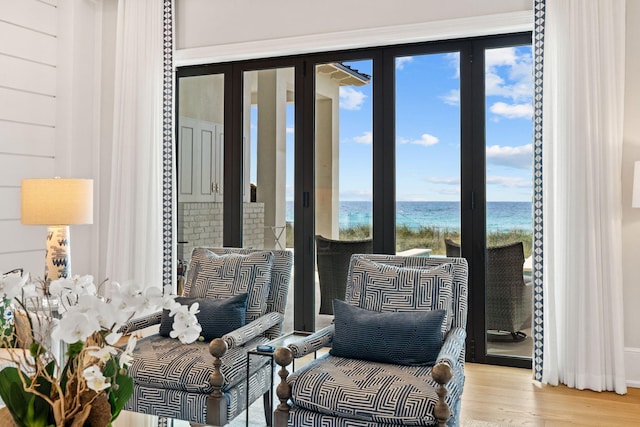 living area featuring a water view, french doors, and light wood-type flooring