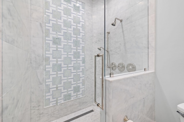 bathroom featuring a tile shower and toilet