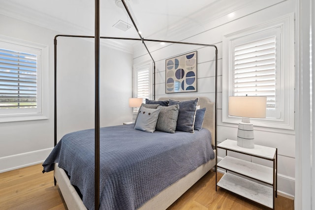 bedroom featuring ornamental molding and light wood-type flooring