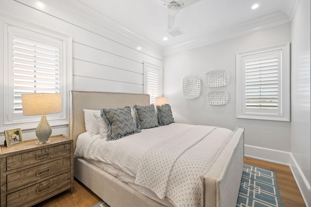 bedroom with ornamental molding, ceiling fan, hardwood / wood-style floors, and multiple windows