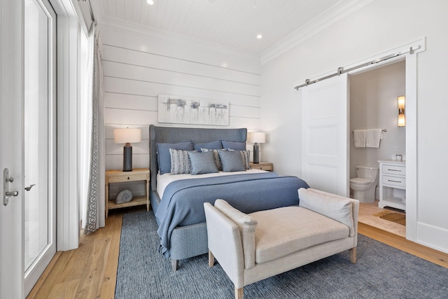 bedroom with light hardwood / wood-style flooring, crown molding, and ensuite bath