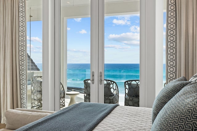 bedroom with french doors and a water view