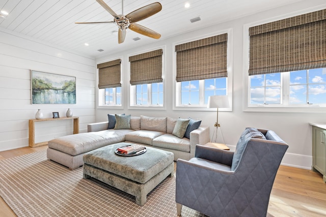 living room featuring ceiling fan, light wood-type flooring, and plenty of natural light