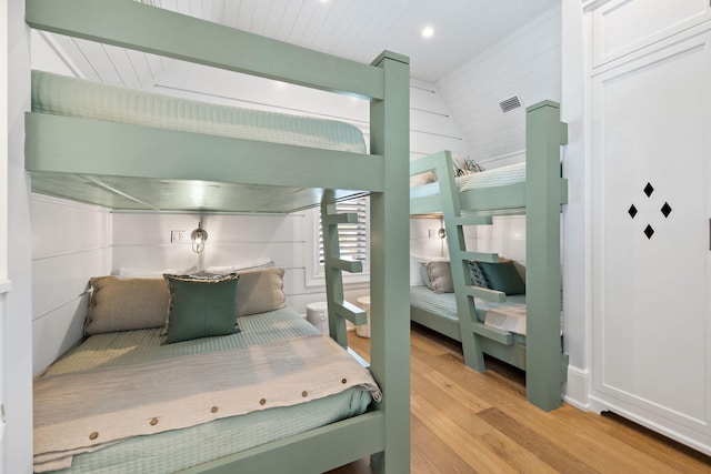 bedroom with light hardwood / wood-style floors and lofted ceiling