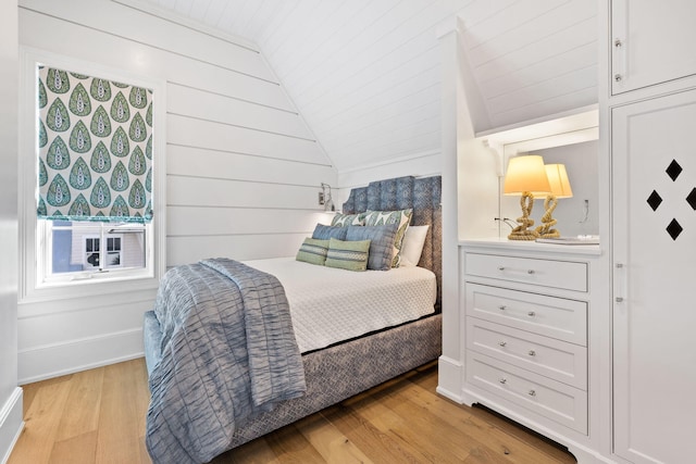 bedroom with vaulted ceiling and light wood-type flooring