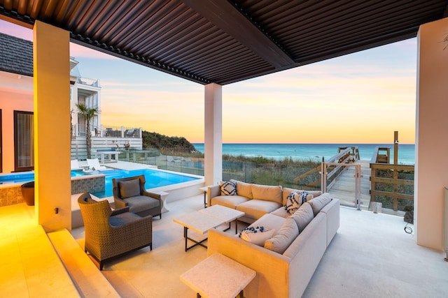 patio terrace at dusk featuring an outdoor living space and a water view