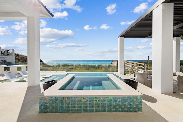 view of pool with a patio area, an in ground hot tub, and a water view