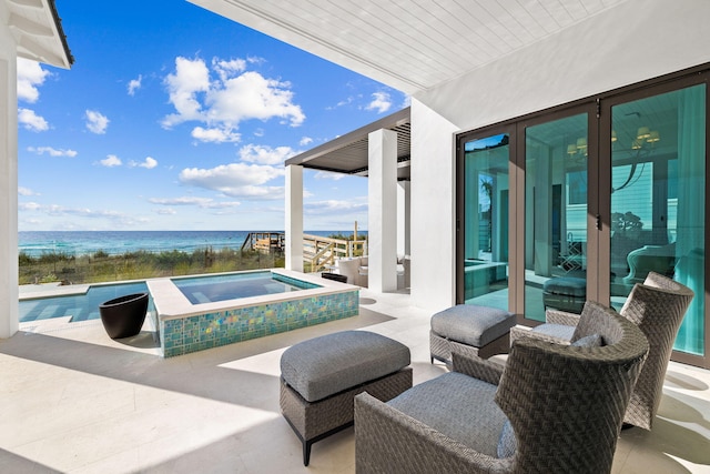 view of patio / terrace with a pool with hot tub and a water view