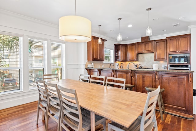 dining room featuring plenty of natural light, dark hardwood / wood-style flooring, and ornamental molding