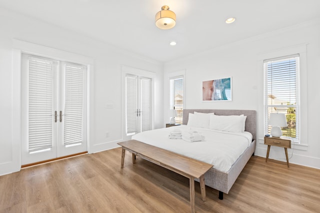 bedroom featuring light hardwood / wood-style flooring, french doors, and multiple windows