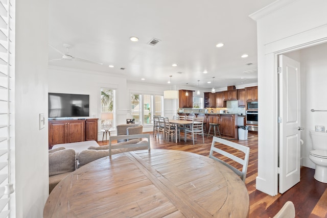 living room featuring ornamental molding, dark hardwood / wood-style flooring, and ceiling fan