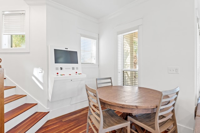 dining area featuring ornamental molding and dark hardwood / wood-style flooring