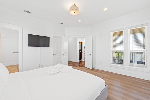 bedroom with light hardwood / wood-style floors and ornamental molding