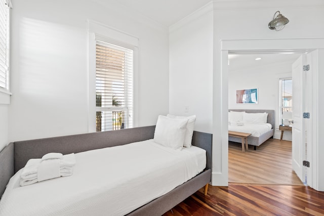 bedroom featuring ornamental molding and dark hardwood / wood-style flooring