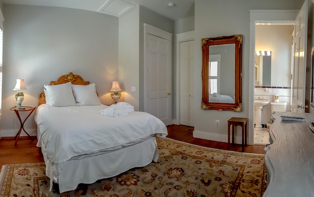 bedroom featuring ensuite bath, a closet, and hardwood / wood-style flooring