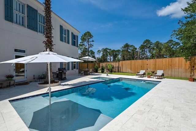 view of pool with area for grilling and a patio area