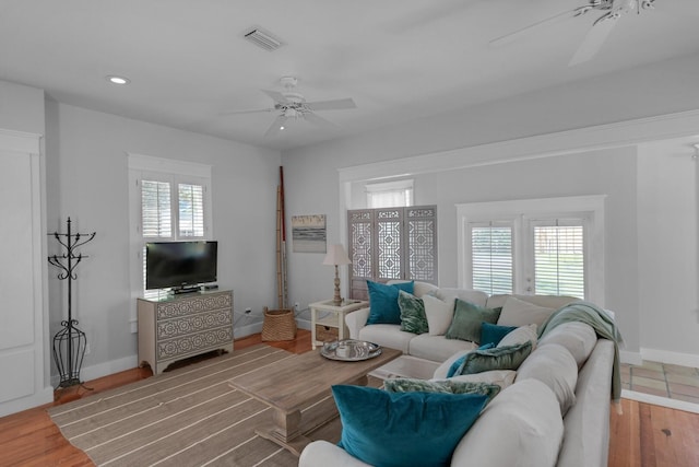 living room featuring ceiling fan, plenty of natural light, and wood-type flooring