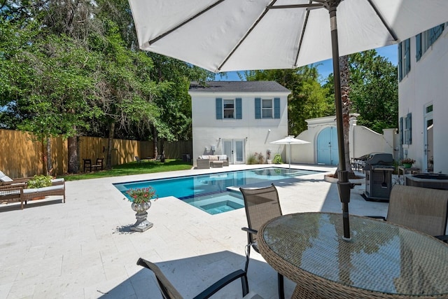 view of swimming pool featuring an in ground hot tub, area for grilling, and a patio area