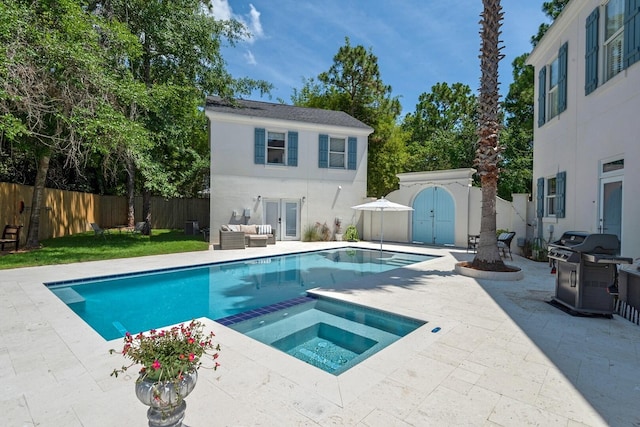 view of pool with an in ground hot tub, a patio, and a grill