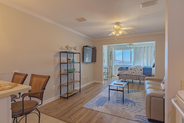 living room with ceiling fan, light hardwood / wood-style floors, and ornamental molding