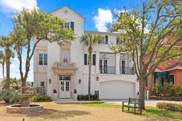 view of front of property with french doors, a balcony, and a garage