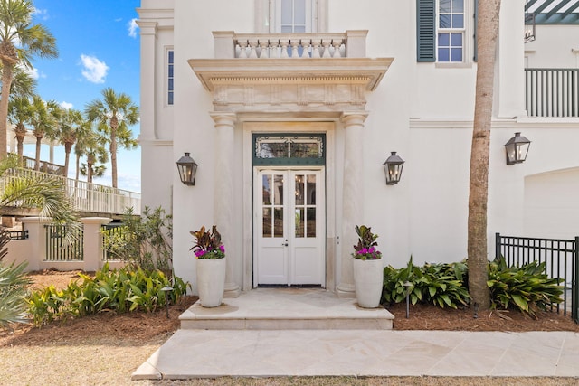 property entrance featuring fence and stucco siding