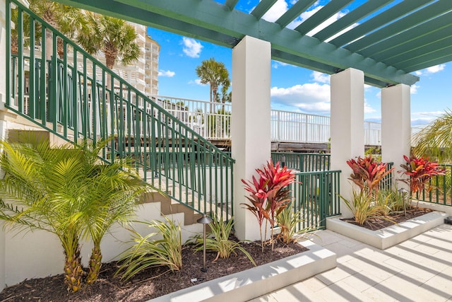 balcony featuring stairs and a pergola