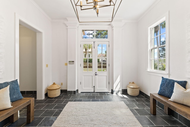 interior space featuring ornamental molding, dark tile flooring, and an inviting chandelier