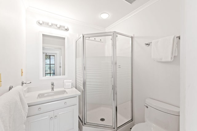 full bathroom with ornamental molding, a shower stall, toilet, and vanity