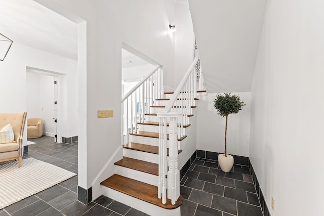 stairs with tile patterned flooring, baseboards, and crown molding